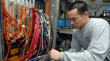 Technician working on network equipment cabling